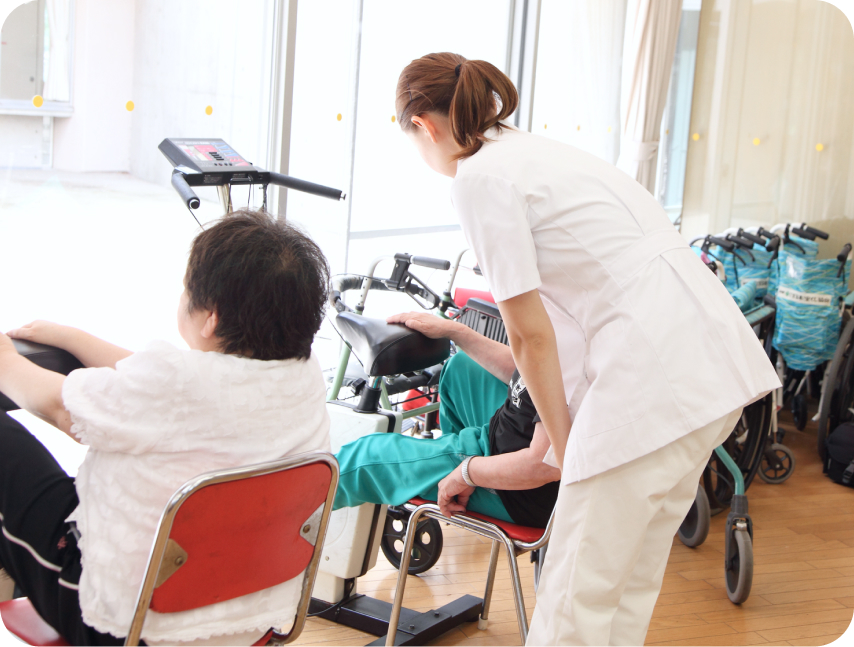 A型事業所 向いている人 リハビリ機器を使用してトレーニングする高齢者とサポートする看護師