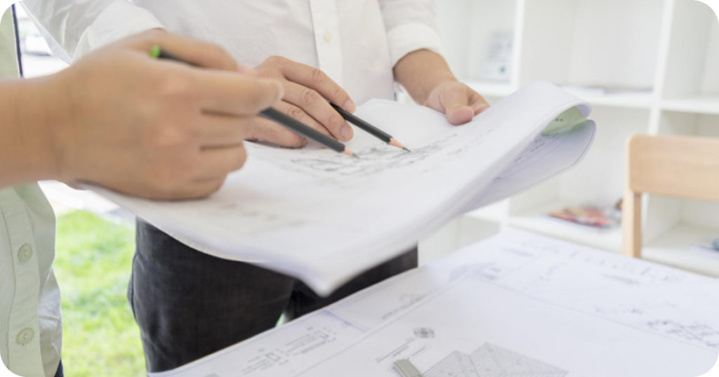A型事業所 収入 建築図面を見ながら打ち合わせをする2人の手元