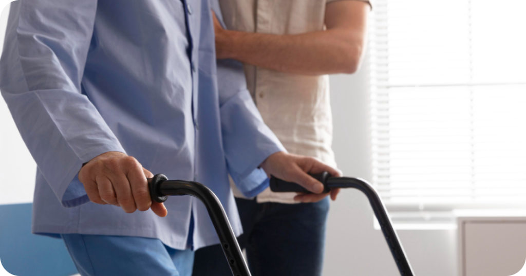 就労継続支援A型 歩行器を使用して歩行練習をする高齢者と、それを支える介助者