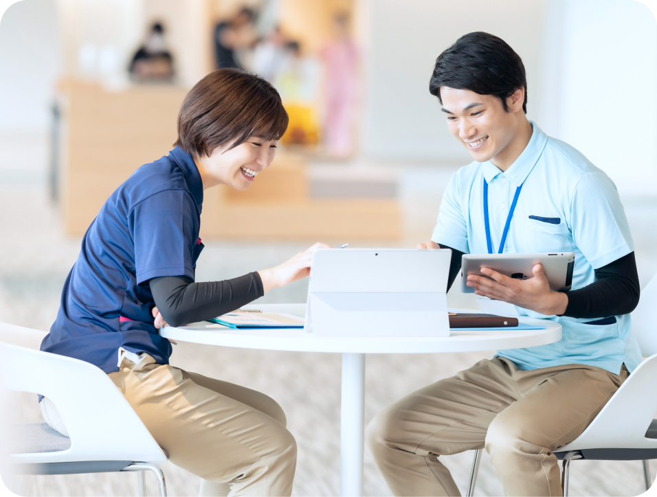 A型事業所 支援員 求人 二人の作業員がパソコンを見ながら話している様子